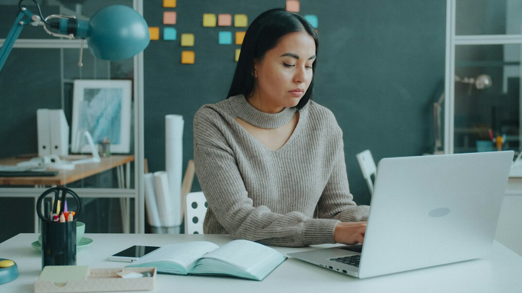 Central European woman software architect working on a laptop